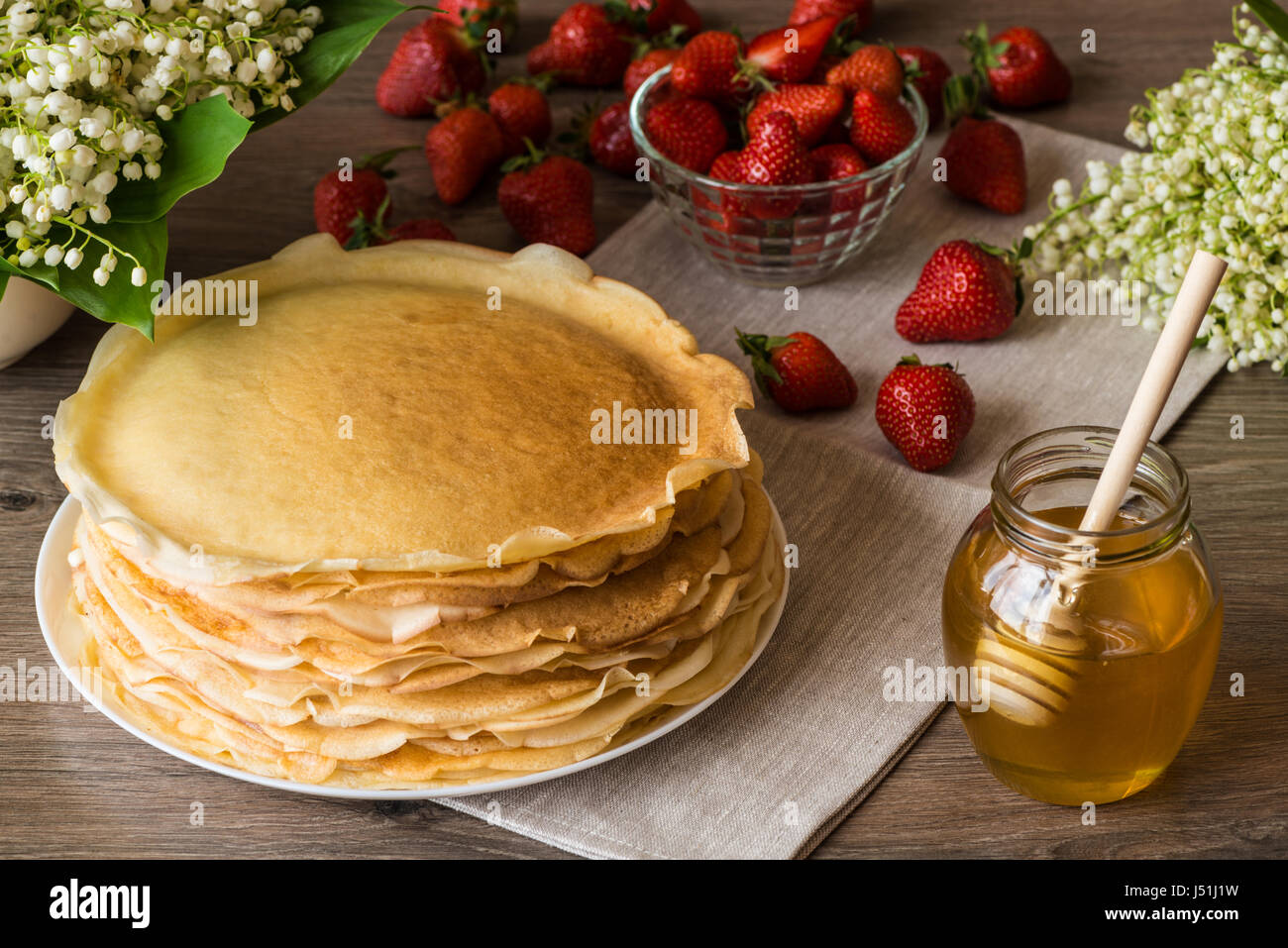 De délicieuses crêpes sur table en bois avec des fraises et miel Banque D'Images