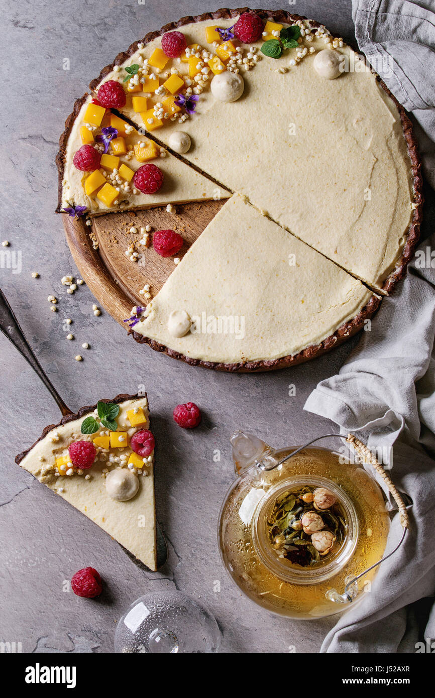 Des Tranches De Tarte Au Chocolat Et Un Morceau De Tarte Decore Par La Mangue Framboises Menthe Riz Souffle Et Fleurs Comestibles Servi Avec Theiere En Verre Plus G Photo Stock