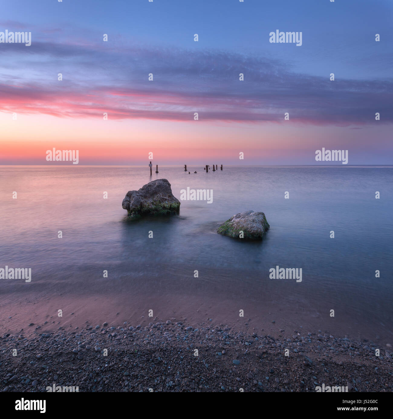 Lever du soleil sur la mer incroyable. Beau paysage avec de l'eau bleu, pierres et ciel coloré avec des nuages en matin d'été. Seascape. Scène tranquille. Natu Banque D'Images