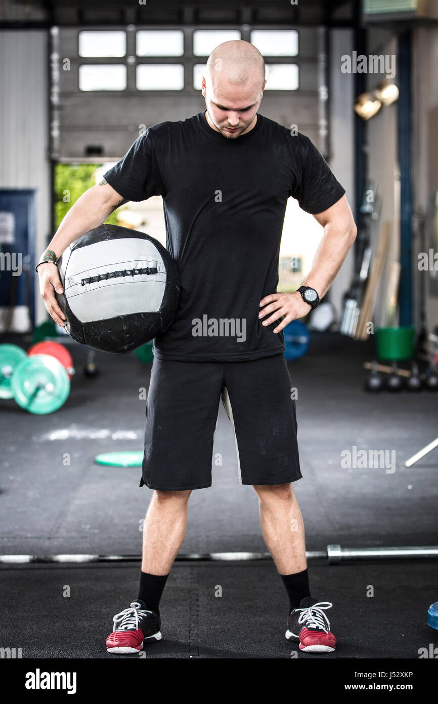 Homme bien formé avec med-bal à la salle de sport Banque D'Images