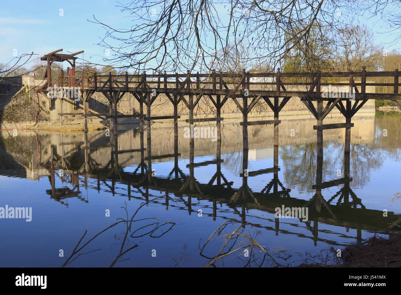 Pont-levis en bois se reflétant dans les douves du château de Sully, France Banque D'Images