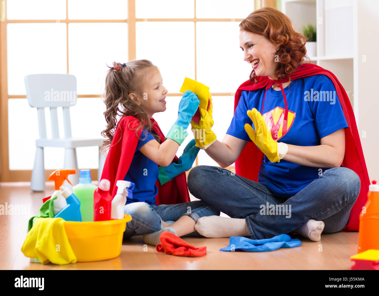 Heureux femme avec enfant chambre de nettoyage et d'avoir du plaisir de jouer à la maison. Famille ménage la conception. Banque D'Images