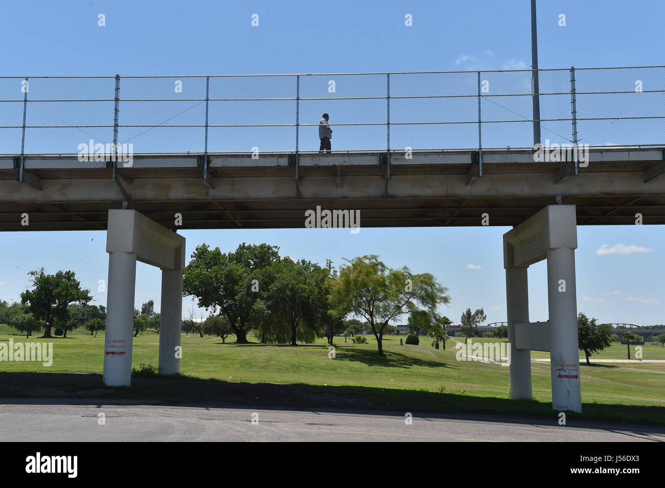 Un homme marche sur le pont International sur un terrain de golf en Eagle Pass, Texas, à Piedras Negras, Mexique. Le golf est à la frontière entre la clôture installée par l'ancien président George Bush et le fleuve Rio Grande. Apr 20, 2017. Crédit : Robin Jerstad/ZUMA/Alamy Fil Live News Banque D'Images