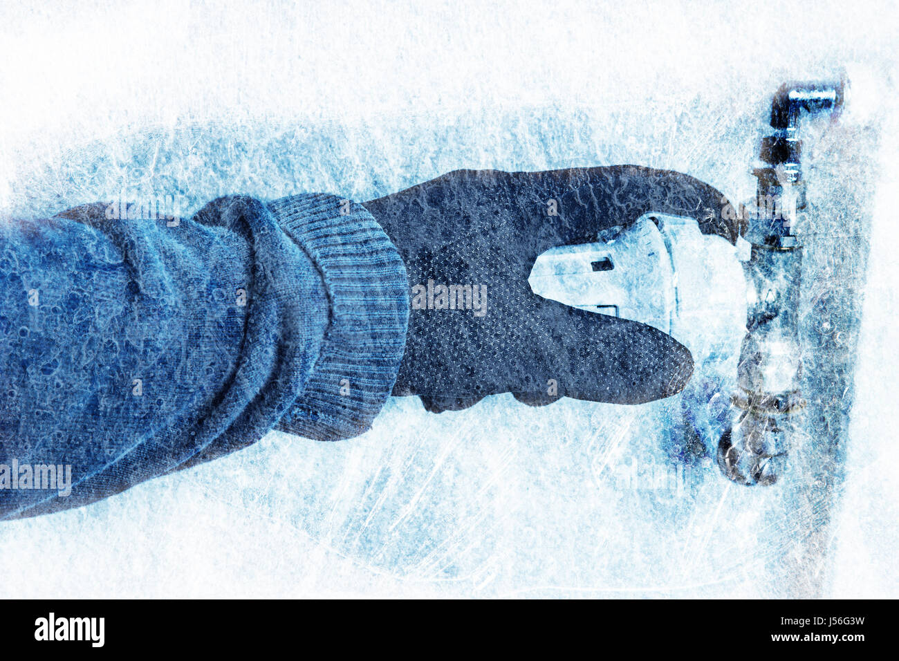 Tourner le gant à la main avec le contrôleur de chauffage pour faire des économies avec la texture de la glace bleu Banque D'Images