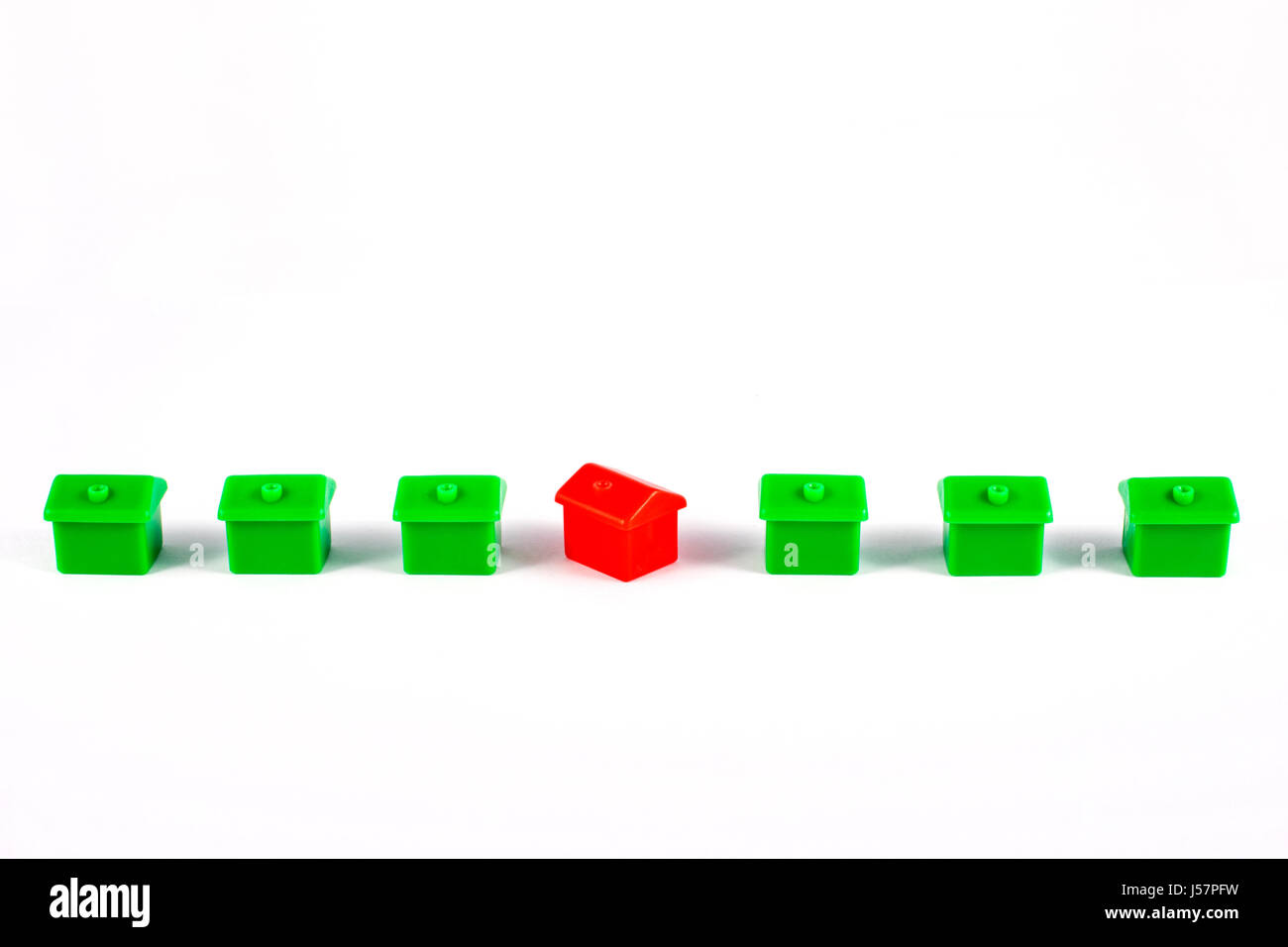 Une rangée de maisons de jouets sur un arrière-plan uni, blanc. Banque D'Images