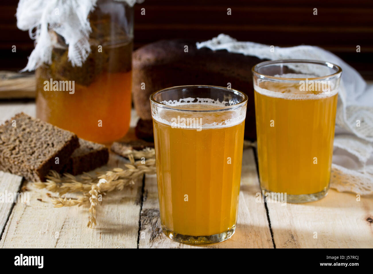 Froid boisson traditionnelle russe seigle kvas dans un verre et une cruche sur une table en bois. De kvas de pain de seigle, de malt, le sucre et l'eau. Banque D'Images
