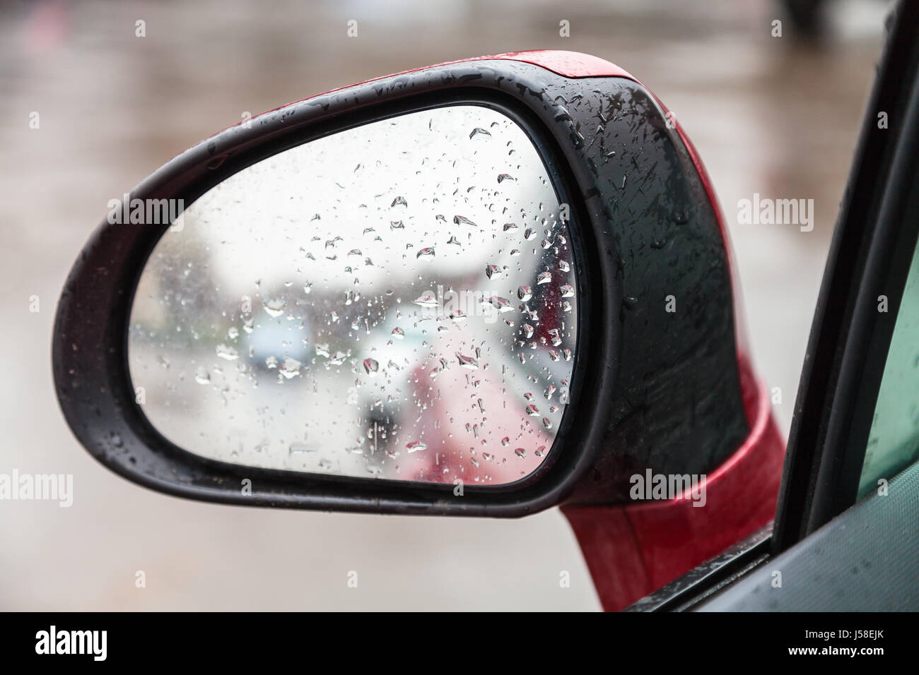 Location de voiture en gouttes de pluie - sur le côté à l'arrière Rétroviseur intérieur jour pluvieux Banque D'Images