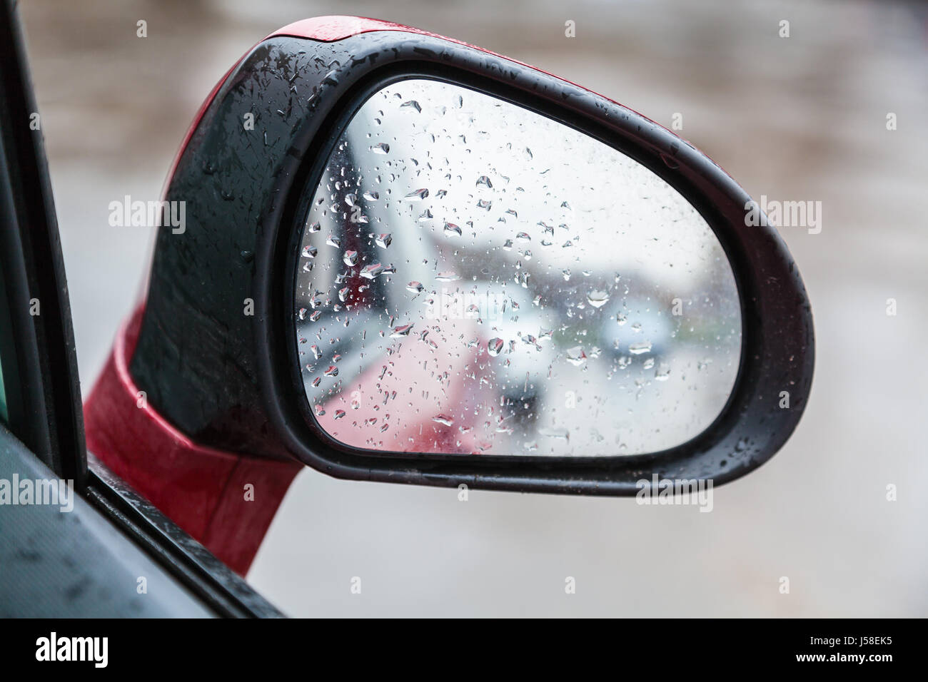Location de voiture en gouttes de pluie - rétroviseur sur le côté en jour de pluie Banque D'Images