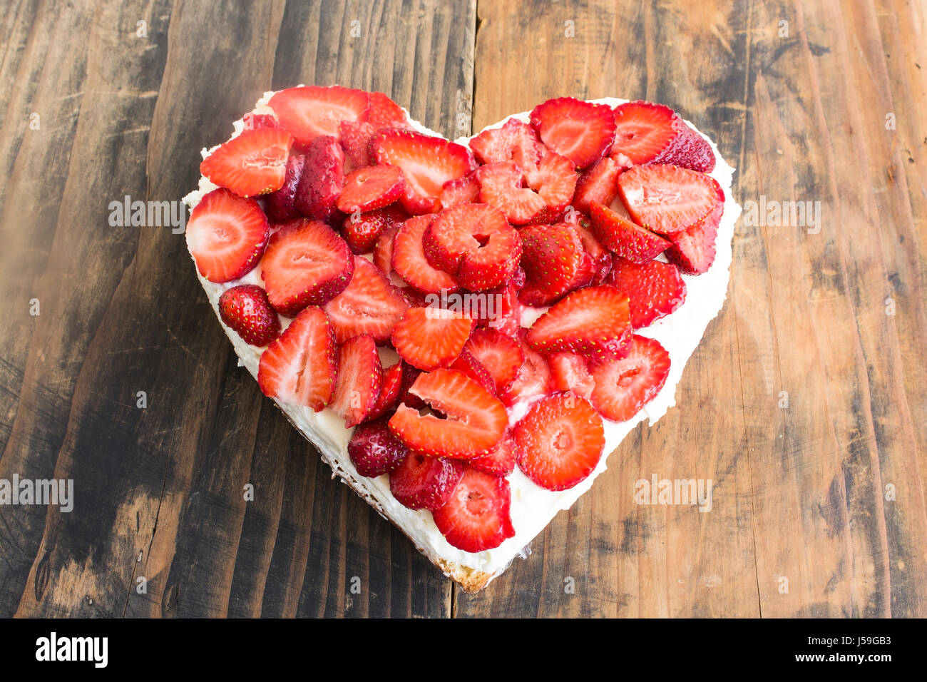 Coeur de fraises Gâteau au fromage sur fond de bois rustique. Banque D'Images