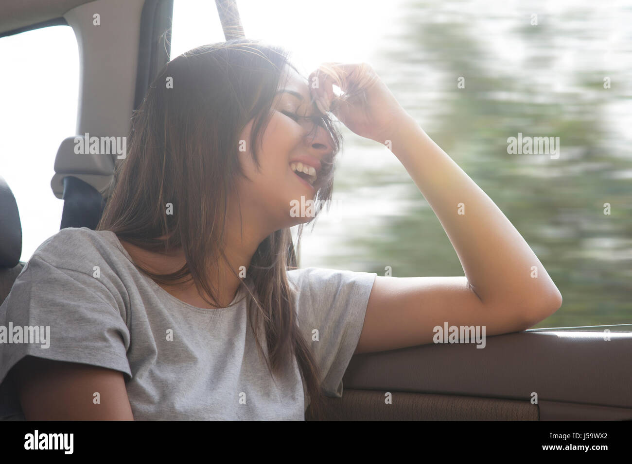 Les jeunes femmes dans les cheveux de voiture est soufflé par le vent Banque D'Images