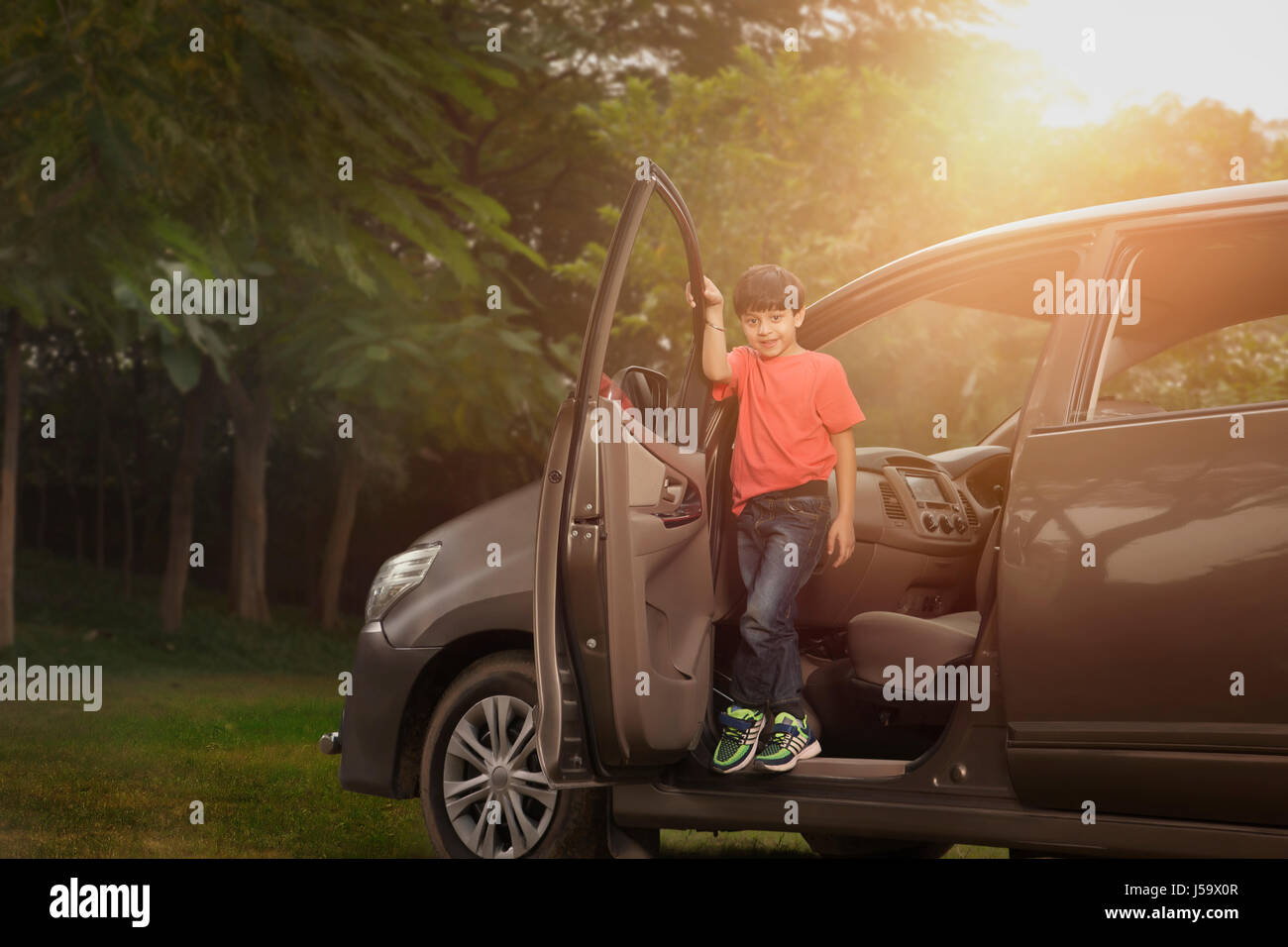 Boy standing in doorway voiture en stationnement Banque D'Images Boy standing in doorway voiture en stationnement Banque D'Images