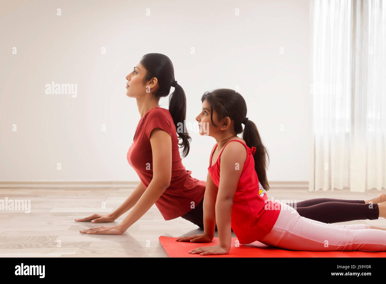 Mère et fille practicing yoga in home Banque D'Images