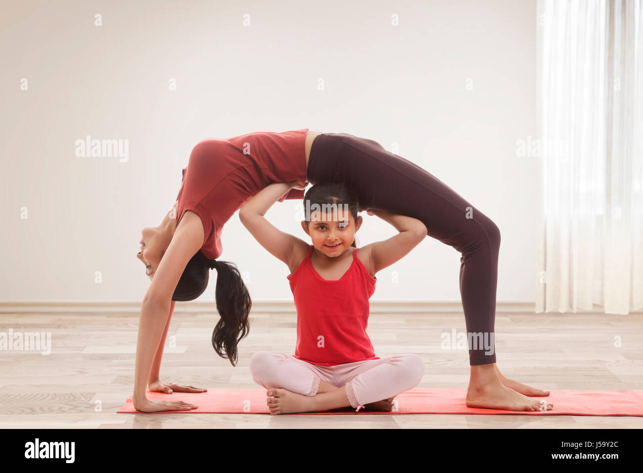 Mère et fille en faisant du yoga accueil Banque D'Images