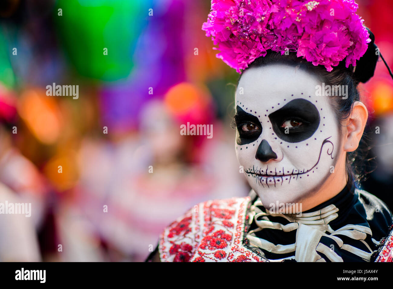 Une jeune femme, habillée comme La Catrina, promenades à travers la ville pendant le Jour des Morts procession dans la ville de Mexico, Mexique. Banque D'Images