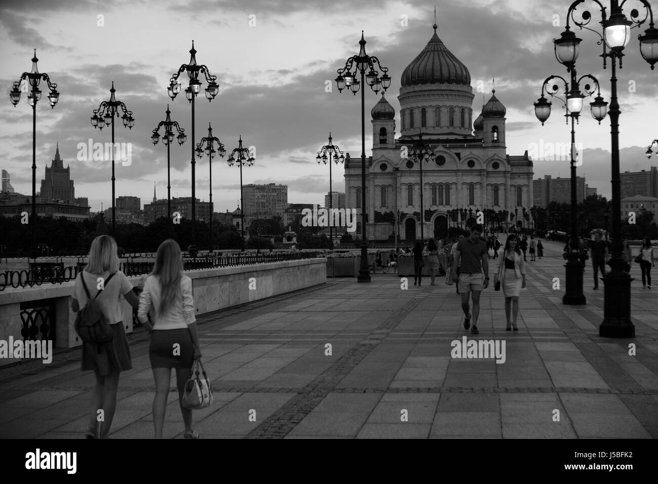 Chaude soirée d'été dans la ville européenne. Lentement les gens à pied sur le centre ville. Sur un arrière-plan le grand temple chrétien est visible. Banque D'Images