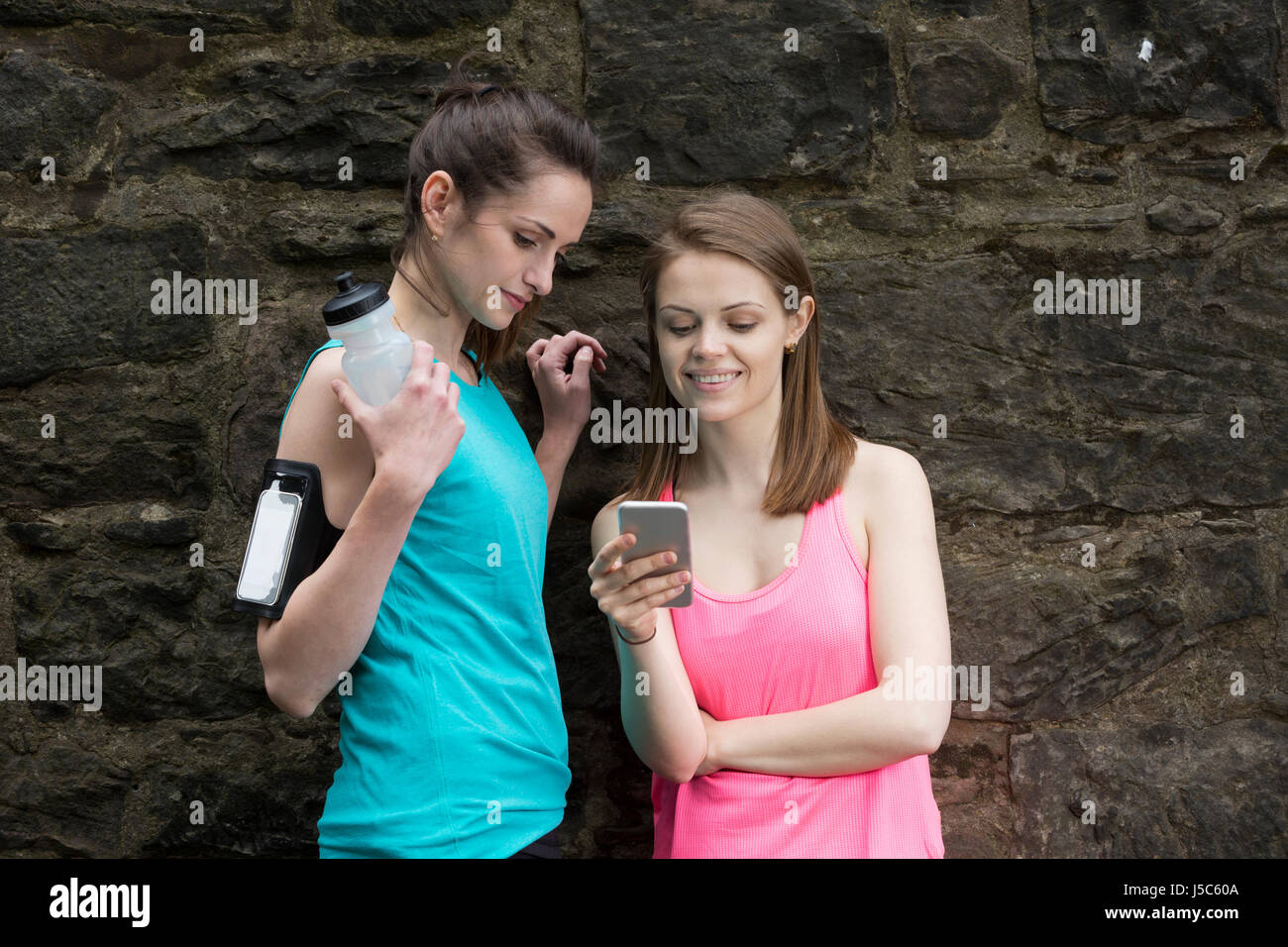 Deux dames partager l'information sur smartphone après y aller pour une exécution. Concept d'action et d'un style de vie sain. Banque D'Images