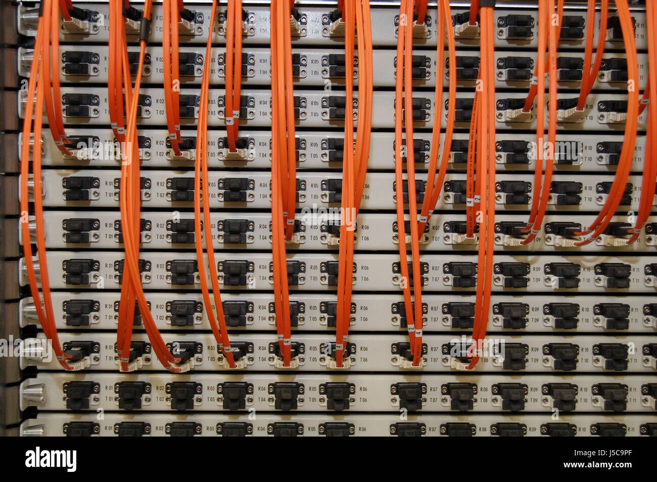 Branchez la lumière lasers laser-vague orange câble patch panel antistatique d'interconnexion Banque D'Images