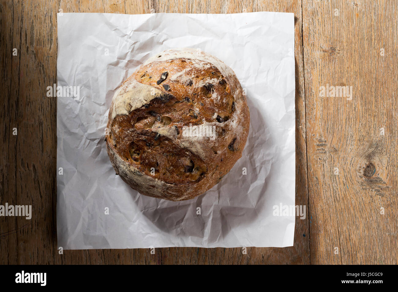 Voir ci-dessus d'une miche de pain rustique sur une vieille table en bois. Banque D'Images