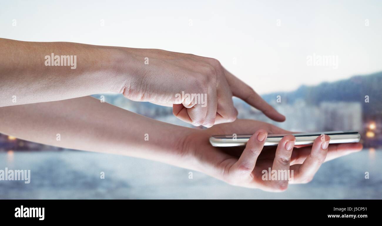 Digital composite des mains avec le téléphone et l'arrondi à l'horizon flou Banque D'Images