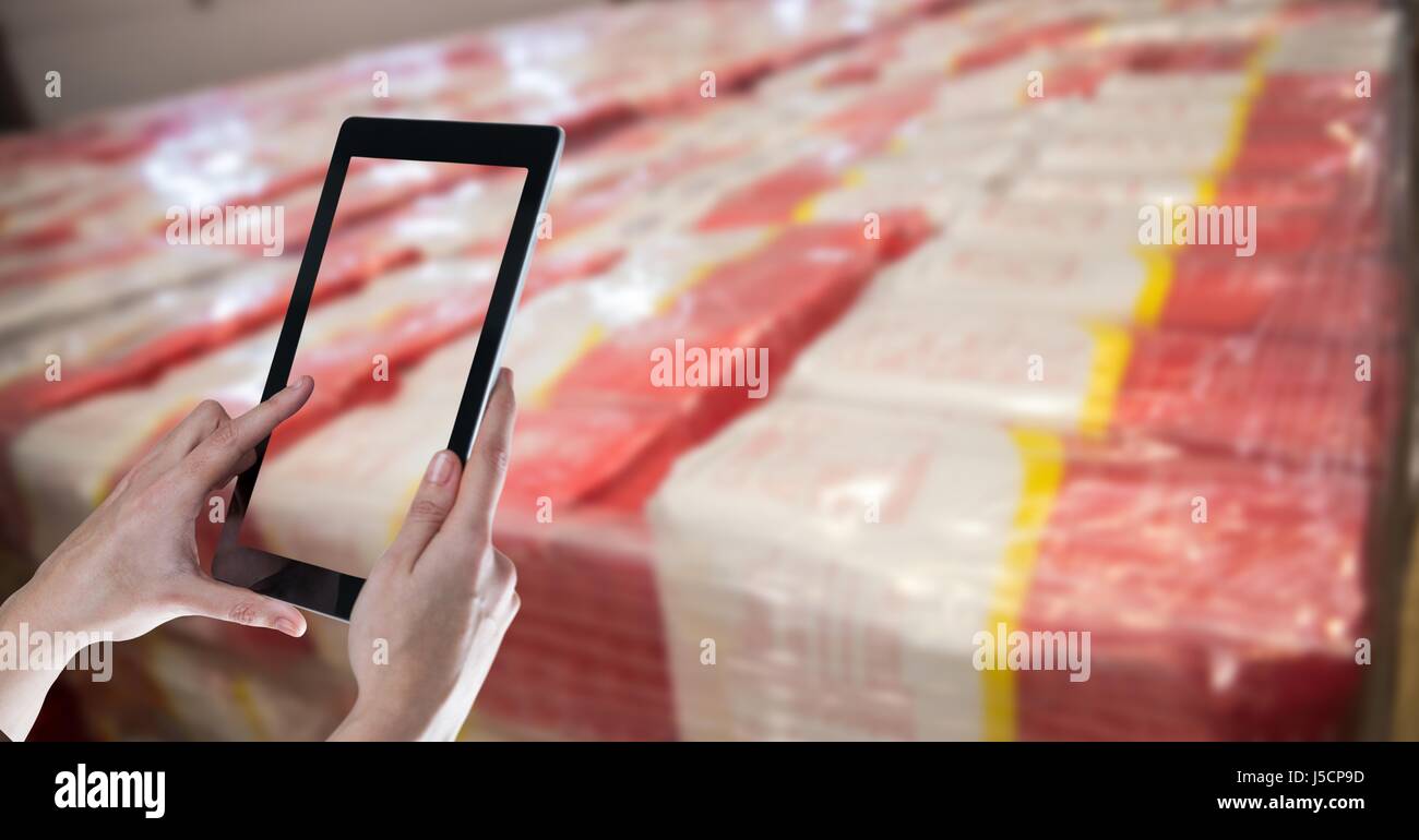Digital composite des mains prendre photo avec tablet PC in warehouse Banque D'Images