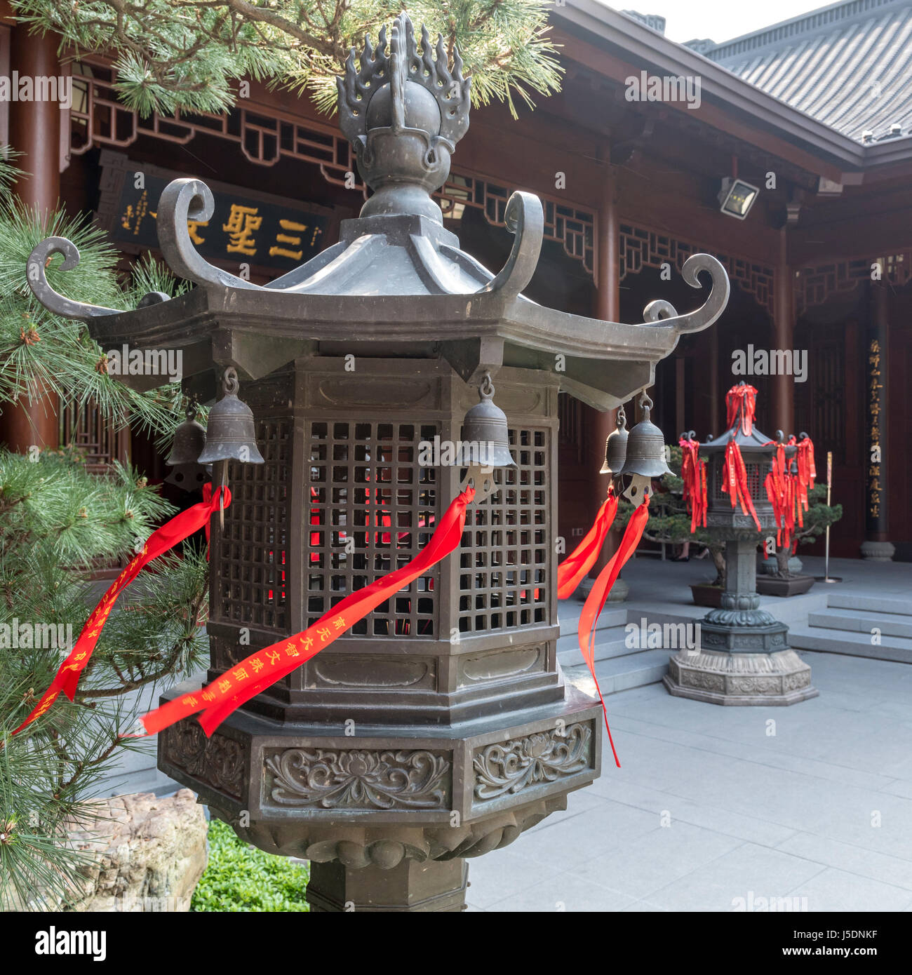 Brass lantern avec drapeaux de prière rouge attaché au temple du Bouddha de Jade à Shanghai Banque D'Images