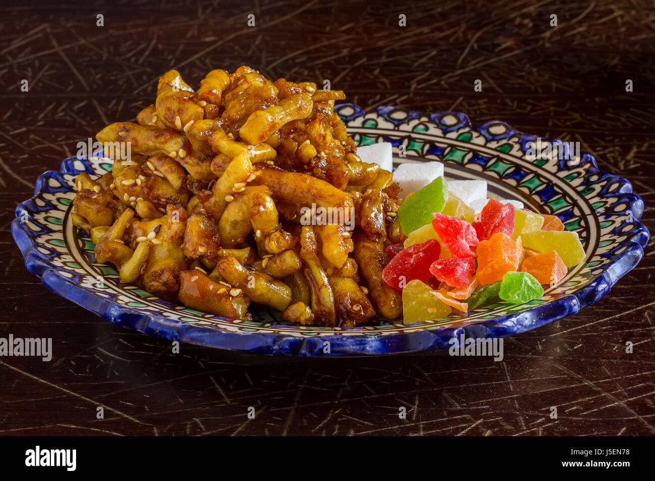 Chak-chak douceurs orientales, les fruits secs et le sucre dans une assiette orientale traditionnelle sur une ancienne surface vernis craquelé Banque D'Images