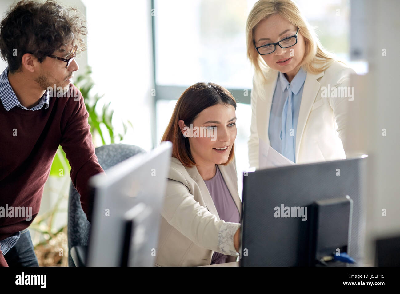 Happy business team with computer in office Banque D'Images