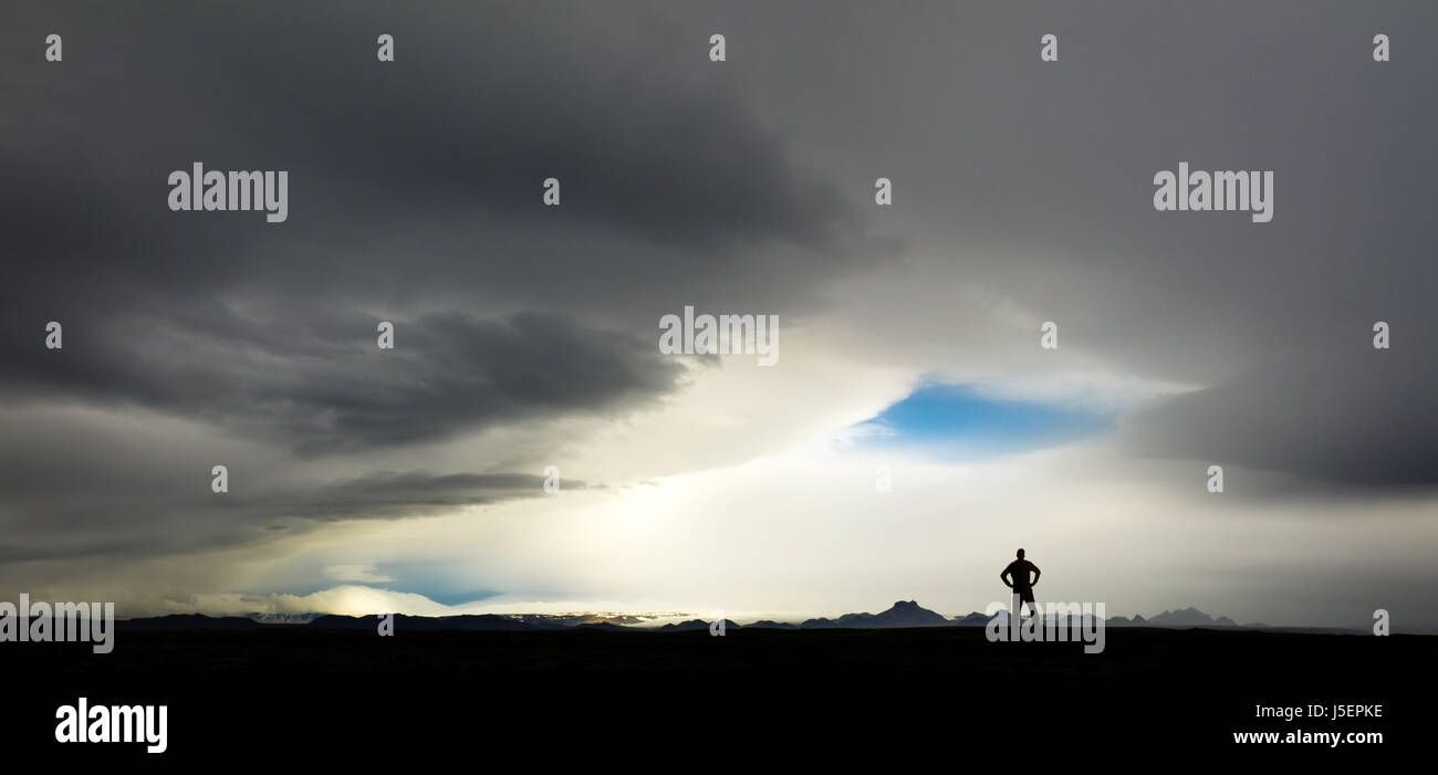 Silhouette of man regarder d'énormes nuages de tempête et en Islande Banque D'Images