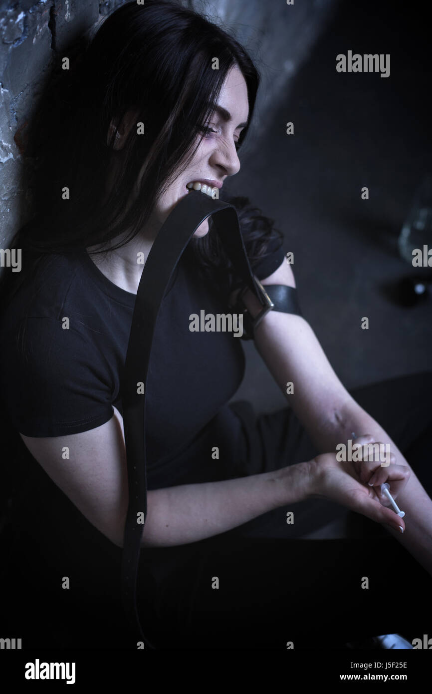 Addicted portrait expressif d'injection de drogue dans l'obscurité Banque D'Images