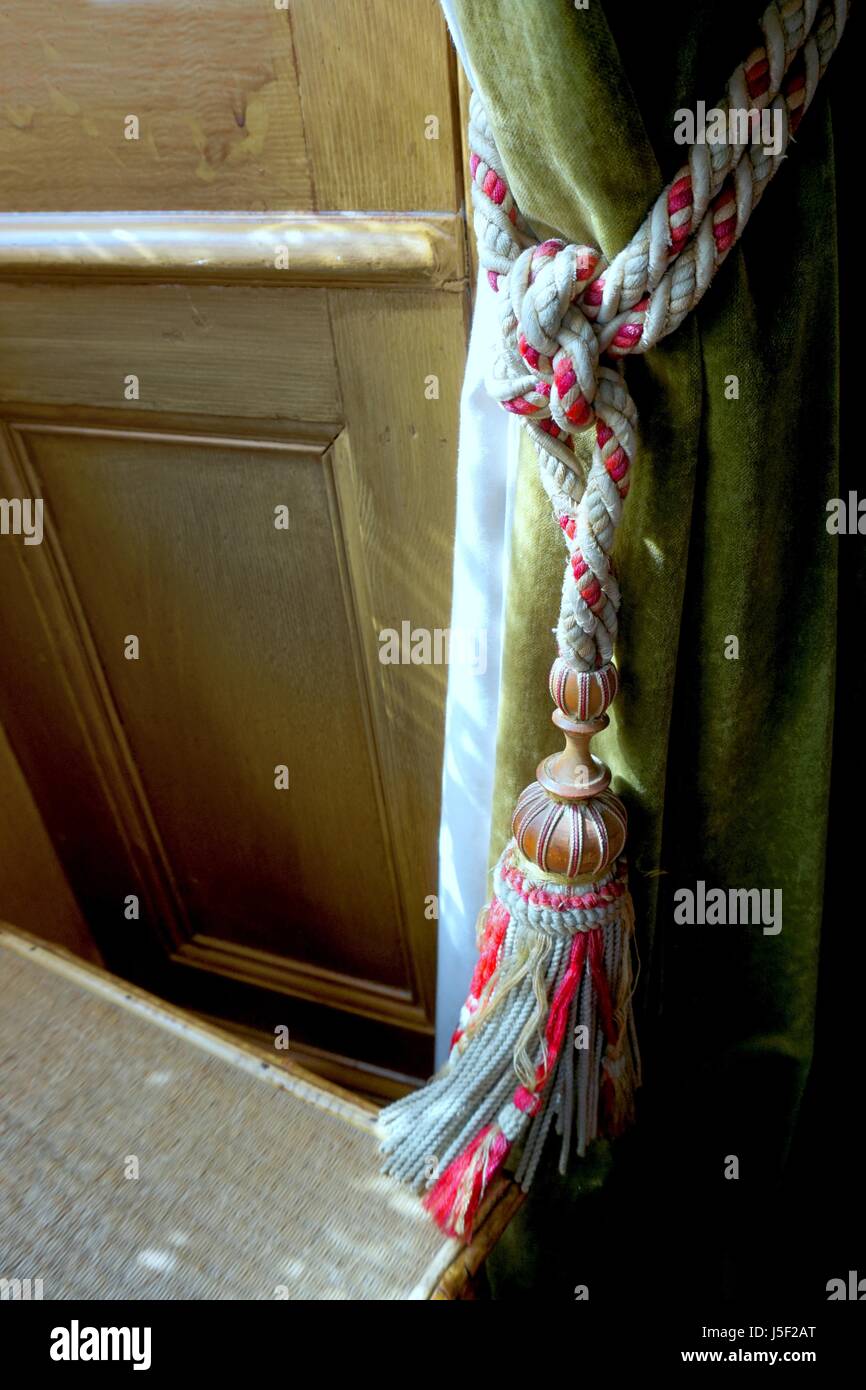 Joli rideau délicat attacher sur un rideau vert naturel dans la lumière de la fenêtre Banque D'Images