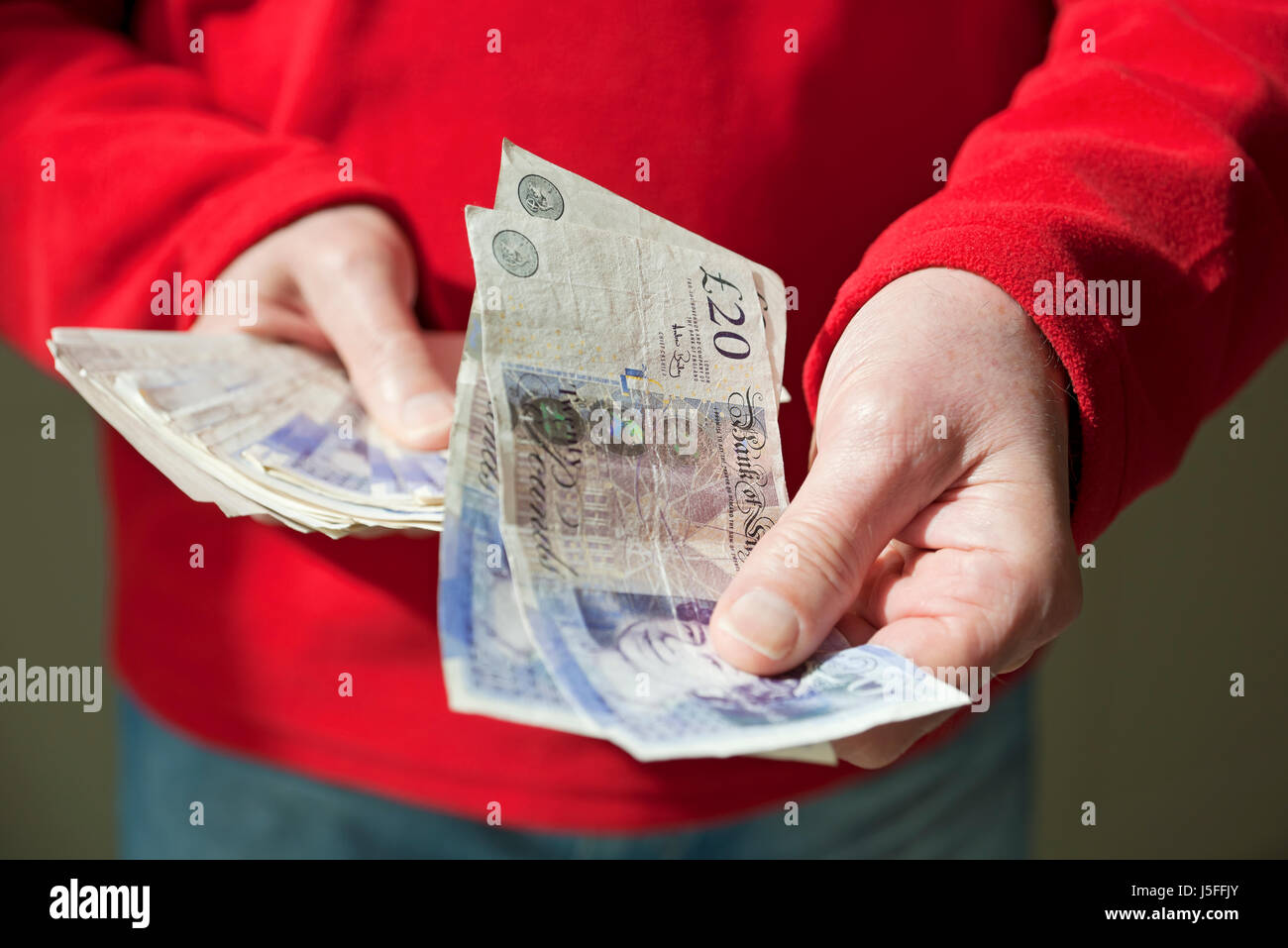Gros plan de l'homme personne détenant des billets de banque britanniques en espèces £20 vingt livres billets Angleterre Royaume-Uni GB Grande-Bretagne Banque D'Images
