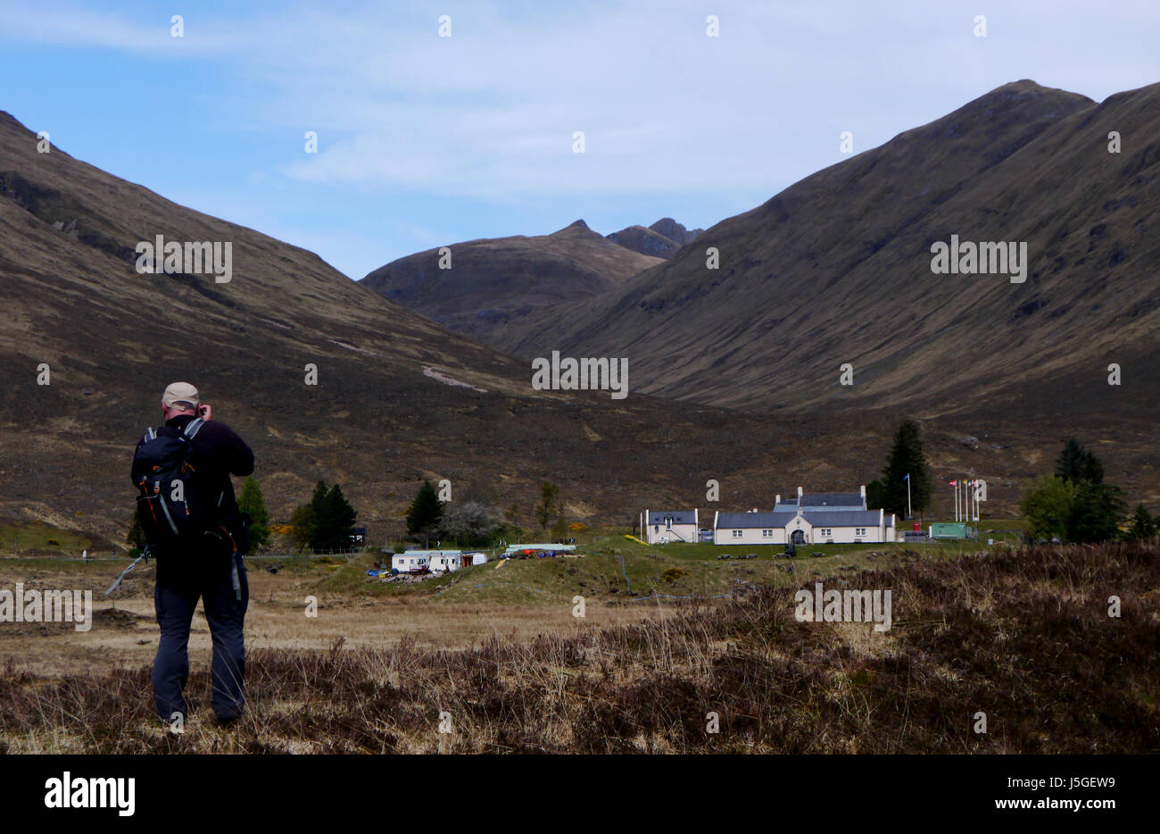 Homme seul Hillwalker Prendre des photos de l'Cluanie Inn et les montagnes écossais Munro et le Dhubn Ciste Corbett suis Bathach dans Glen Shiel, Kintail, Banque D'Images