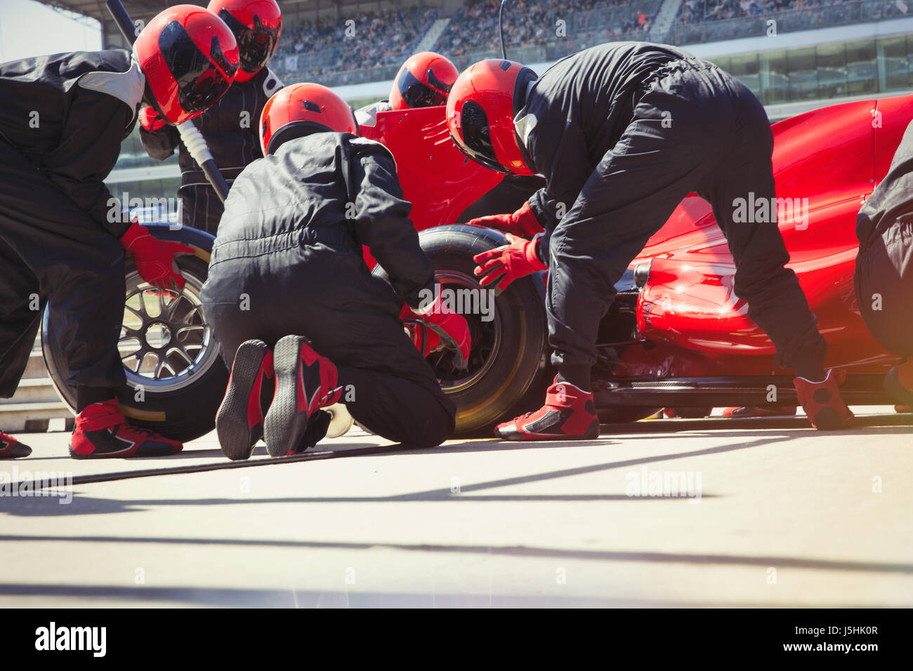 Pit Crew du remplacement des pneus de voiture de course de Formule 1 dans la voie des stands Banque D'Images