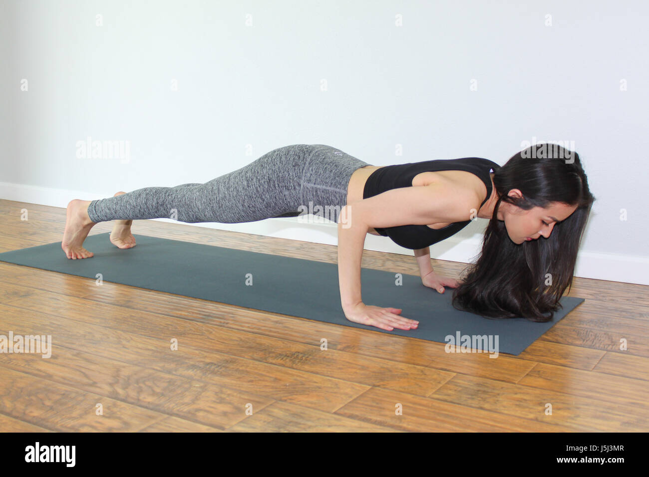 Beautiful woman sitting on a appelé chaturanga dandasana planche ou faible. Banque D'Images