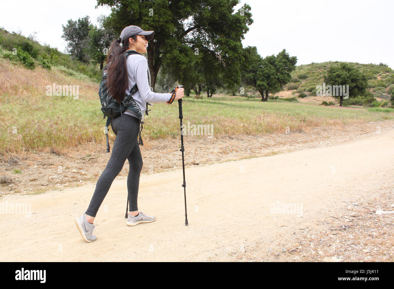 Belle femme à l'aide de bâtons de marche sur un sentier de randonnée. Banque D'Images