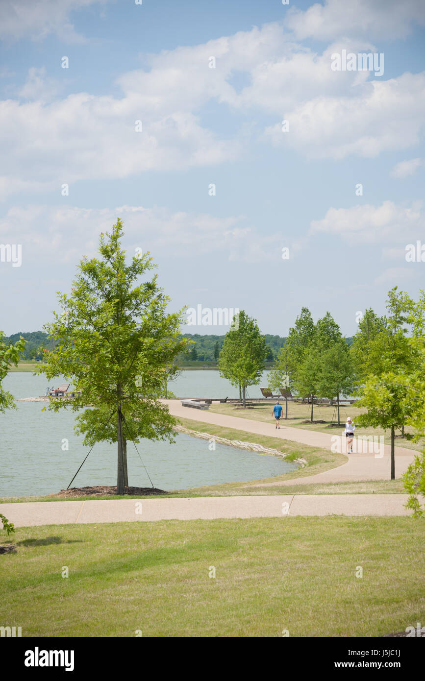 Les marcheurs et coureurs à Shelby Farms Park profiter de l'ensoleillement du printemps autour de la piste de 2,5 km autour du lac Patriot. Banque D'Images