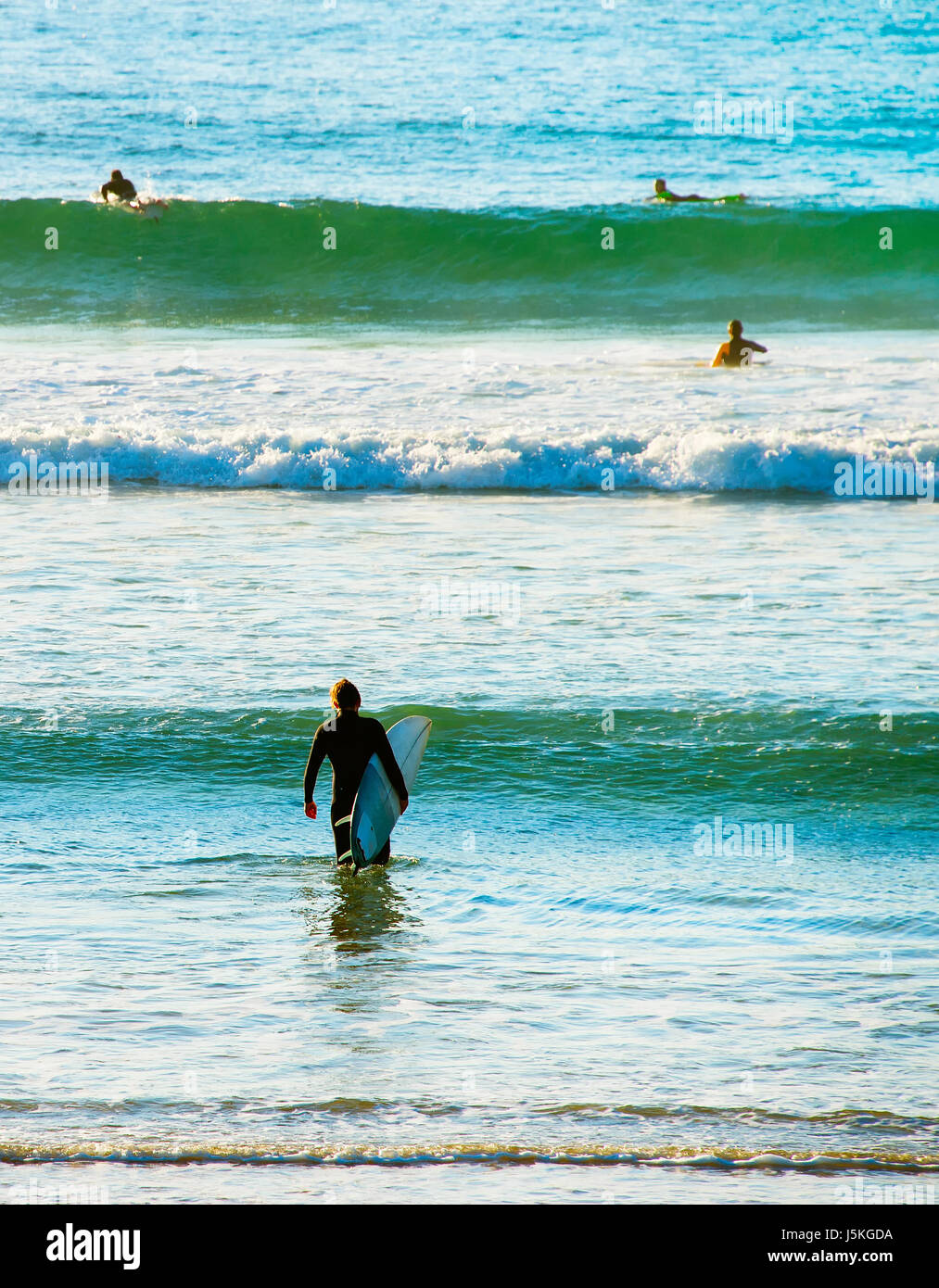 Surfers dans l'océan au coucher du soleil. Portugsl Banque D'Images