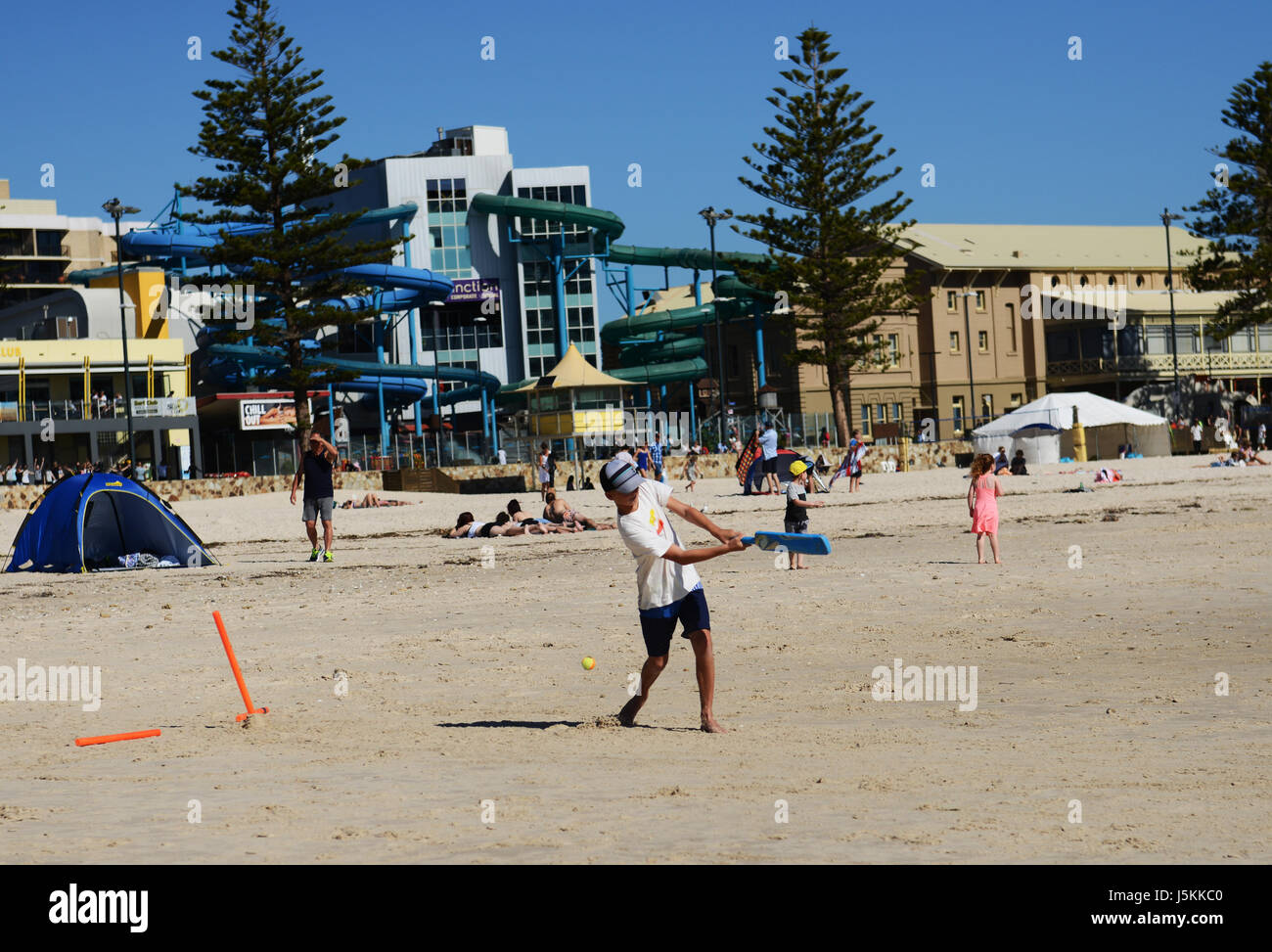 Enfants australiens jouer au cricket à Glenelg Beach près d'Adélaïde. Banque D'Images