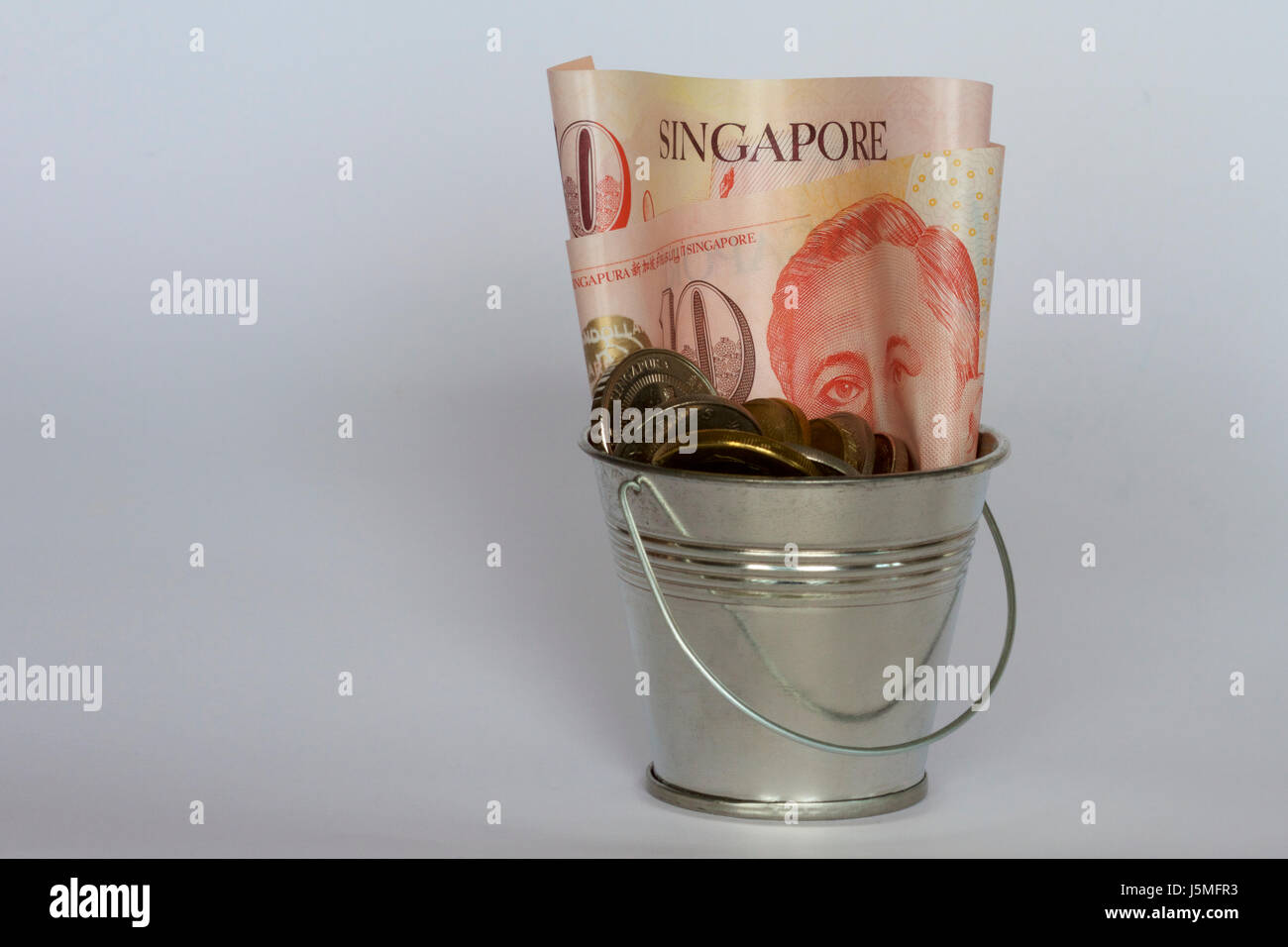 L'argent de Singapour dans un seau. Banque D'Images