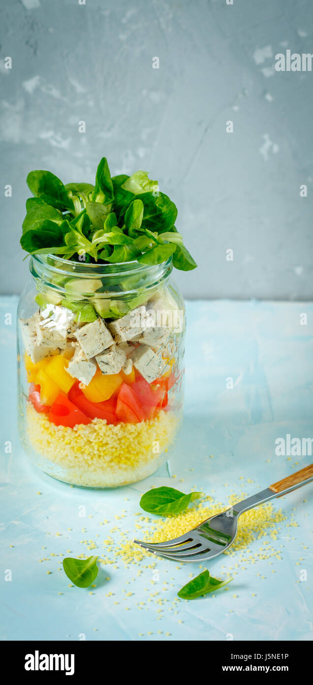 Salade de couscous végétalien, le tofu et les légumes dans un bocal. L'amour pour une saine nourriture vegan concept Banque D'Images