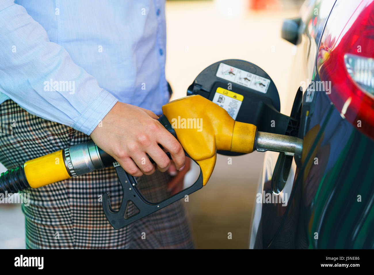 Femme remplit l'essence dans sa voiture à une station-service Banque D'Images