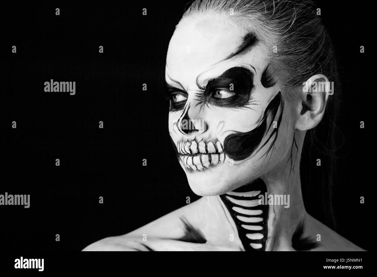 Fille avec creative halloween face art sur fond noir. Banque D'Images