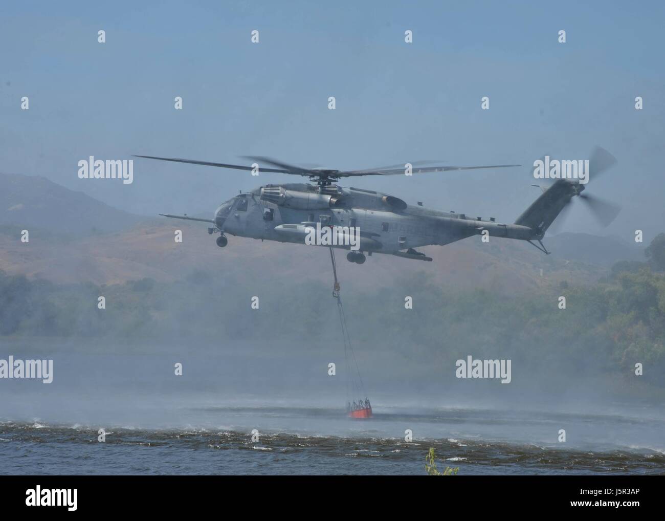 Un hélicoptère Sea Stallion USMC tire l'eau du lac O'Neill dans un seau bambi suspendu pendant un exercice de lutte contre les feux de démonstration au Marine Corps Base Camp Pendleton 4 mai 2017 près de Oceanside, Californie. (Photo de Curtis D. Spencer /US Navy par Planetpix) Banque D'Images