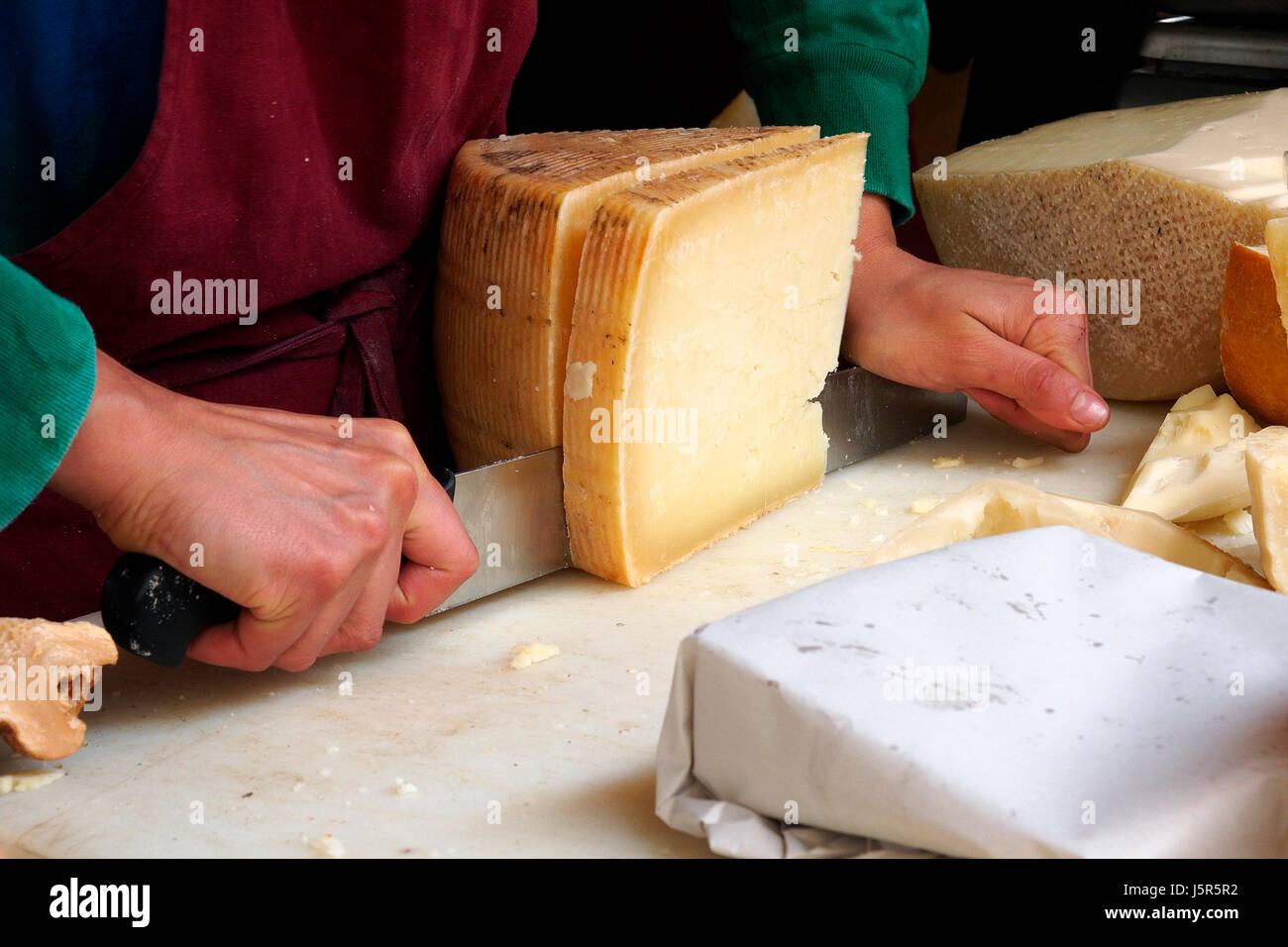 La rue du marché alimentaire. Couper le fromage pecorino. Banque D'Images