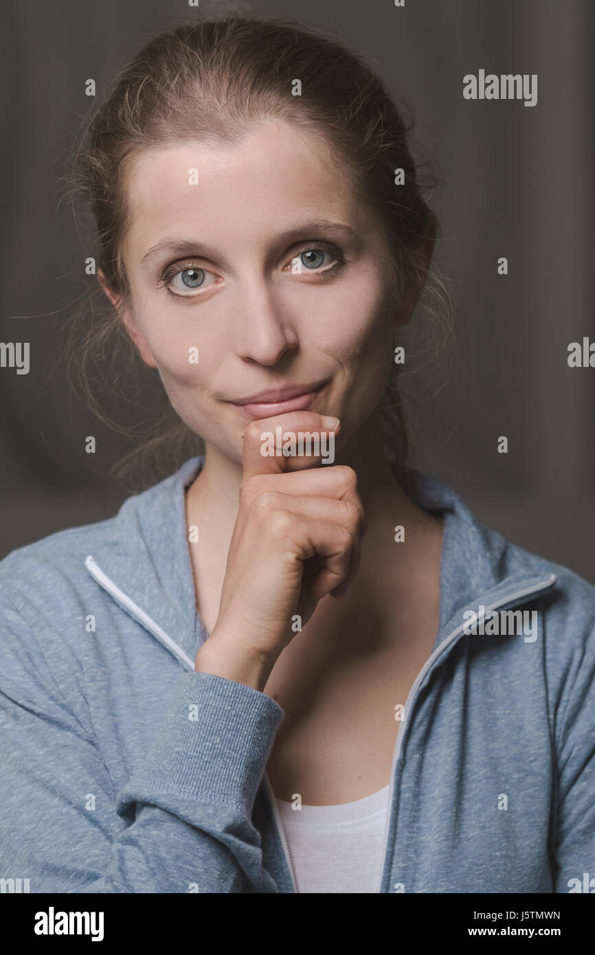Attractive Woman posing and smiling at camera with hand on chin Banque D'Images Attractive Woman posing and smiling at camera with hand on chin Banque D'Images