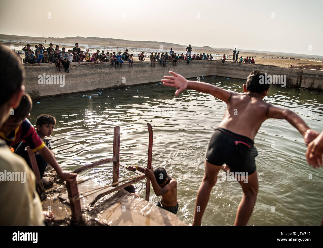 Les enfants nagent dans Hammam Al Alil camp de déplacés, l'Iraq Banque D'Images