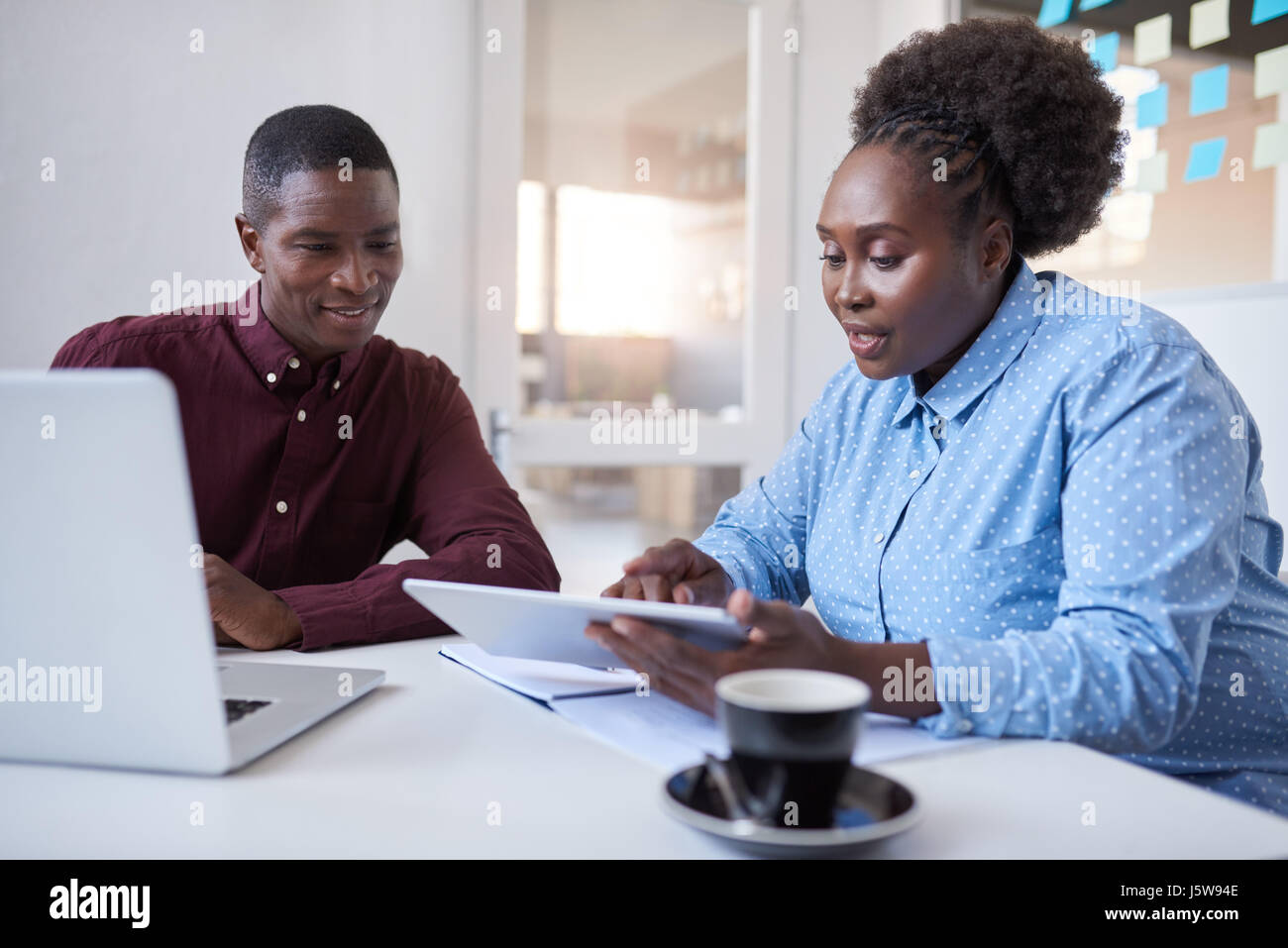 Les jeunes gens d'affaires de l'Afrique de l'utilisation de la technologie ensemble dans un bureau Banque D'Images