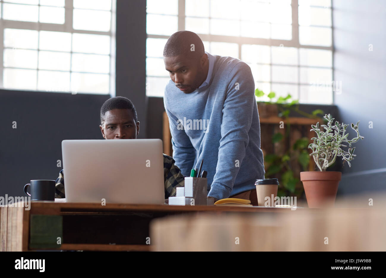 Les jeunes collègues africains à l'aide d'un ordinateur portable ensemble au travail Banque D'Images