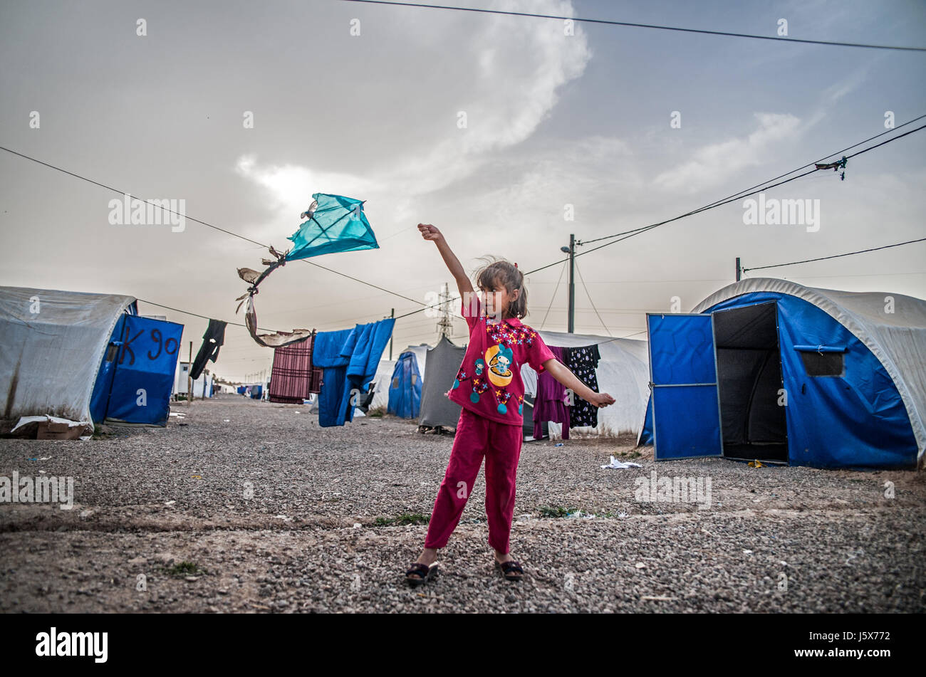 Une fille déplacées joue avec un cerf-volant dans le camp de réfugiés de l'Irak, Khazir Banque D'Images