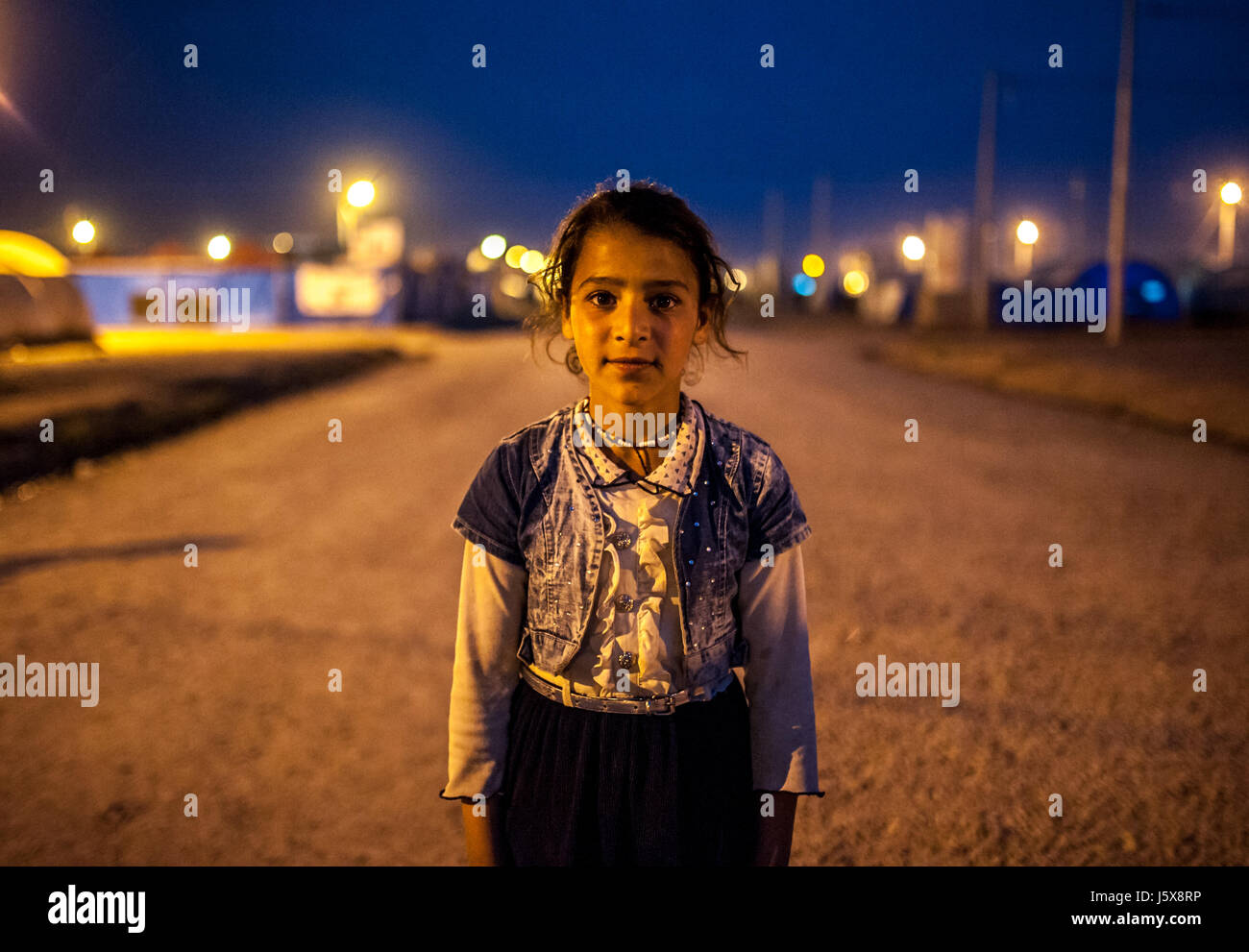 Une jeune fille se tient dans le camp de réfugiés de l'Irak, Khazir Banque D'Images